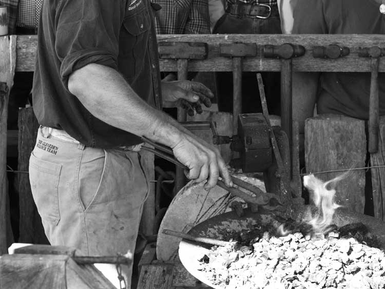 Blacksmith demonstrating - Blacksmithing using an old forge