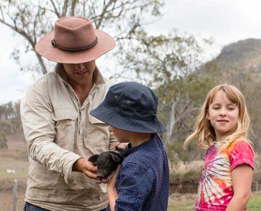 Children cuddling baby pigs